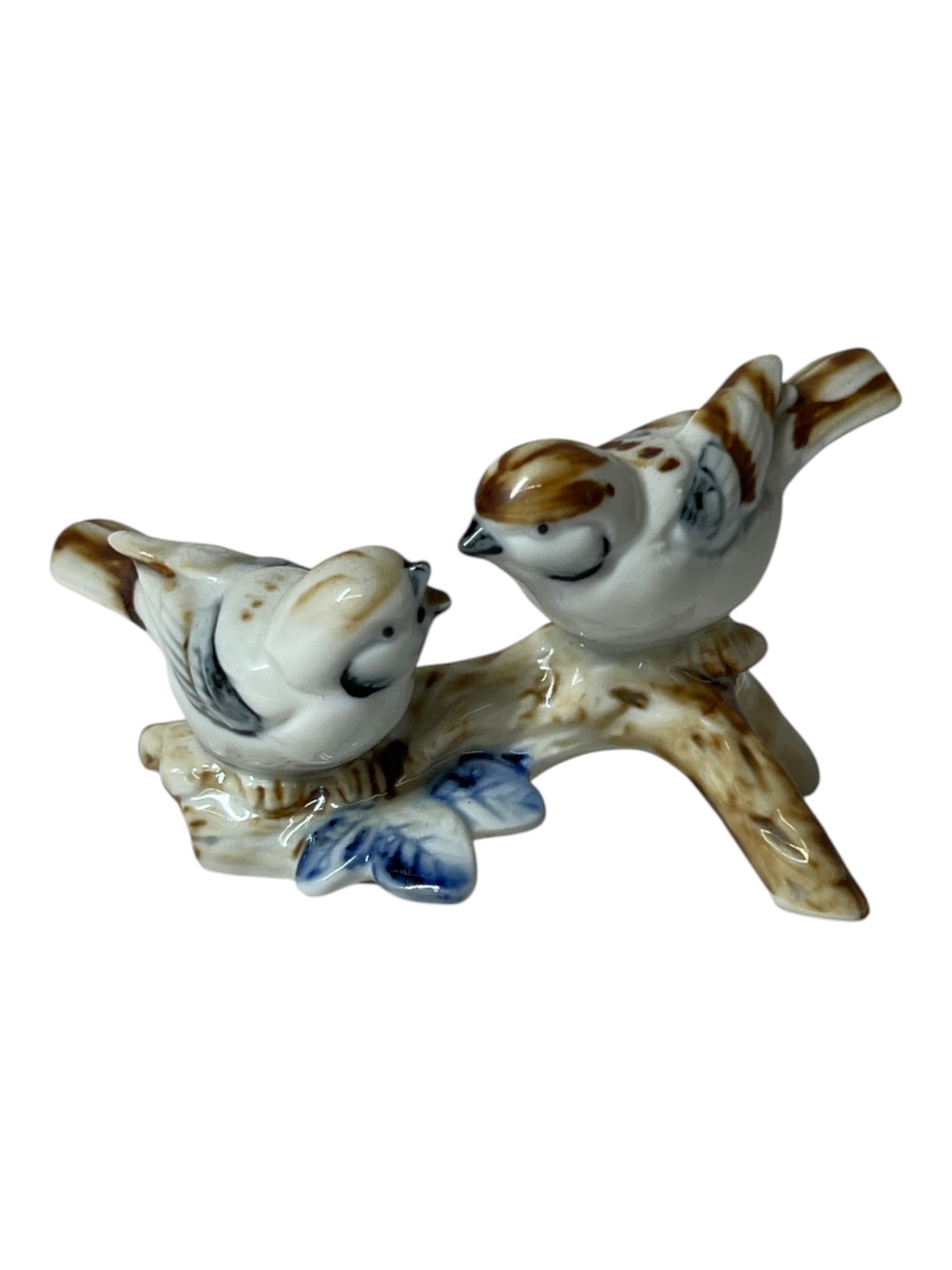 Porcelain Bird Figurine: Decorative porcelain figurine depicting two birds perched on a branch.