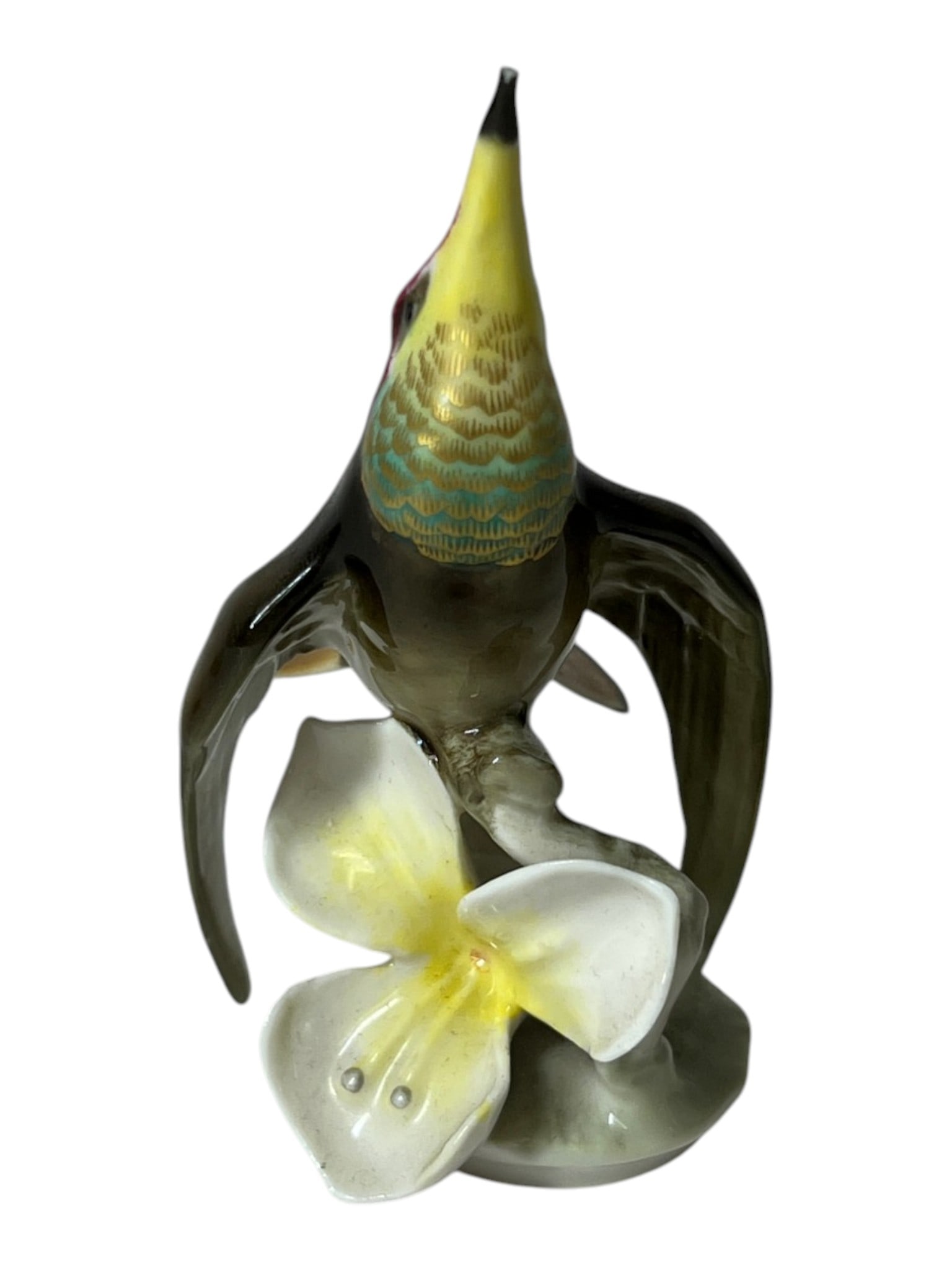 Porcelain Hummingbird Figurine: Decorative porcelain hummingbird perched beside a flower.