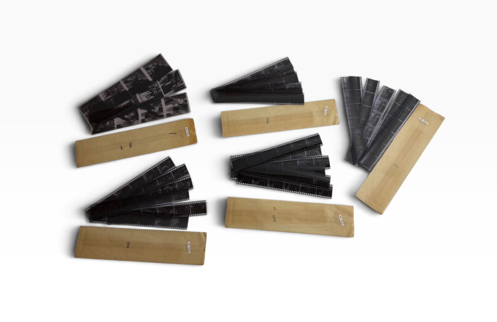 Vintage Adult Film Negative Strips with Original Paper Sleeves: Archive group of vintage photographic negative strips stored with original paper sleeves/envelopes. Adult-themed imagery visible on the negatives. Untested; condition varies.