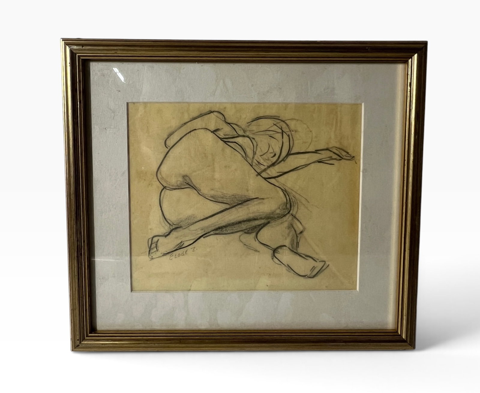 Eloise Z Signed Reclining Nude Figure Drawing: Vintage charcoal or graphite figure study on toned paper depicting a reclining nude female model in a curled pose. Signed 'Eloise Z.' near the lower left. Presented under glass in a gilt frame with ma