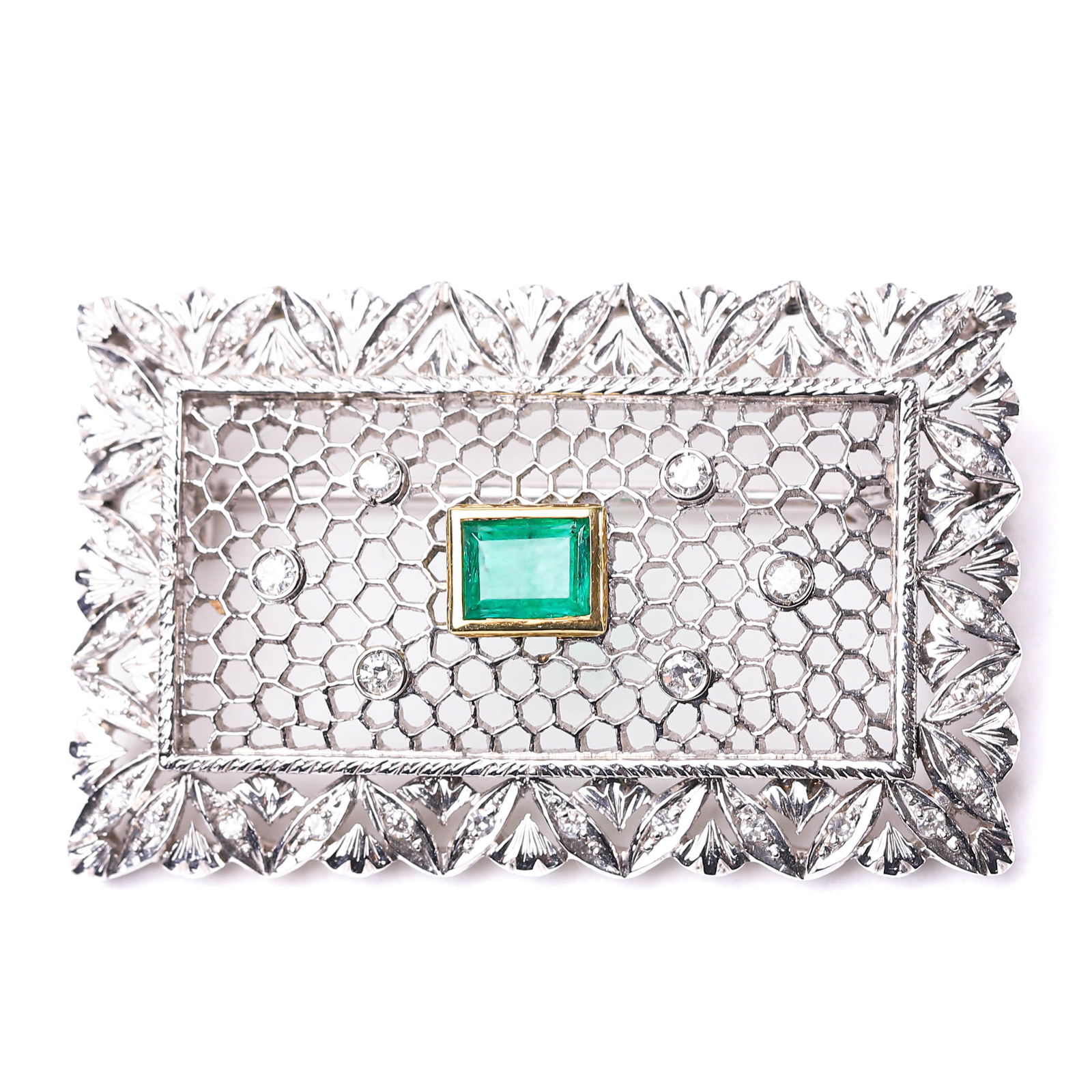 ART DECO DIAMOND AND EMERALD ZUOLOSA BROOCH, 1925-1935.: Dimensions: 1 9/16 x 15/16 in (3.9 x 2.4 cm); Weight: 9.6 g; Period: 1925-1935.This brooch is handcrafted in 18k gold using the intricate "Zolotas" technique, also known as "honeycomb filigree."