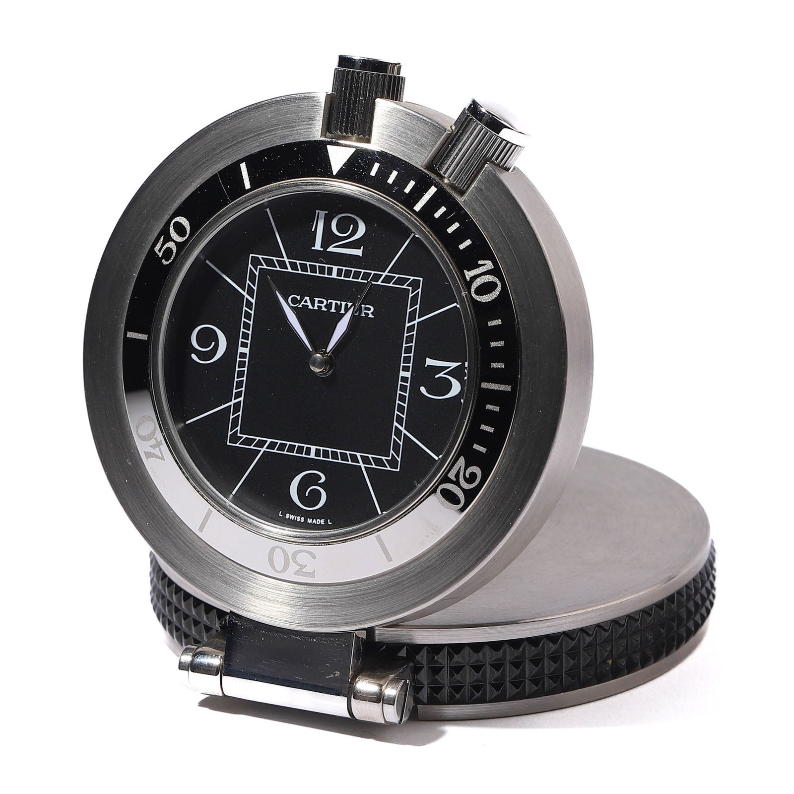 CARTIER TABLE CLOCK: diameter: 2 in (5.1 cm) A round Cartier table clock featuring a stainless steel body with a polished finish. The black dial is accented with white numeral markers and the Cartier logo. The back case