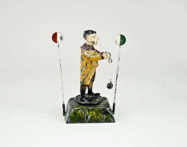 Early Tin Wind-up Toy: 5 1/2" tall, figure rotates when wound hitting pole on either side.