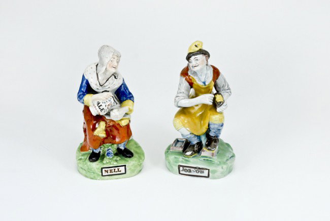 Pair of Early 19th C. Staffordshire Figures: Jobson, (boot repairer) and Nell, his "Missus". Nell has wear to one arm and coattail and a hairline to base. Each measure 6 1/4" tall.