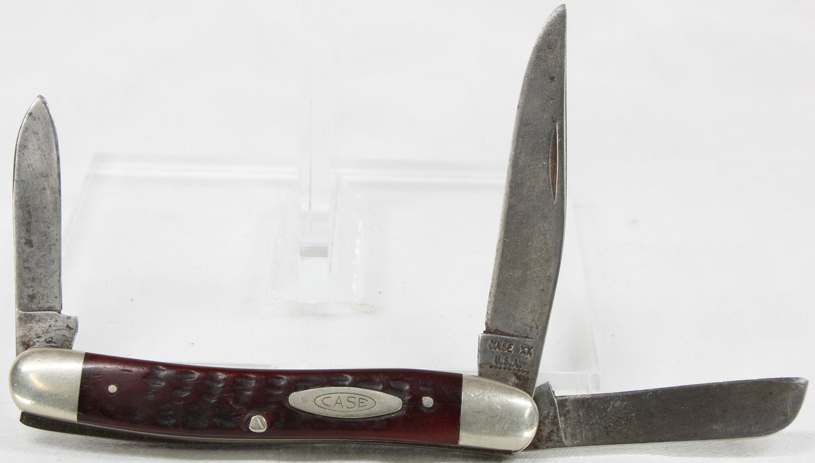 Case Folding Pocket Knife - 3 Blade Stockman: Case XX USA folding pocket knife featuring three blades in the traditional stockman pattern with jigged dark red handles, oval Case shield, and nickel silver bolsters. Knife shows moderate to heavy ha