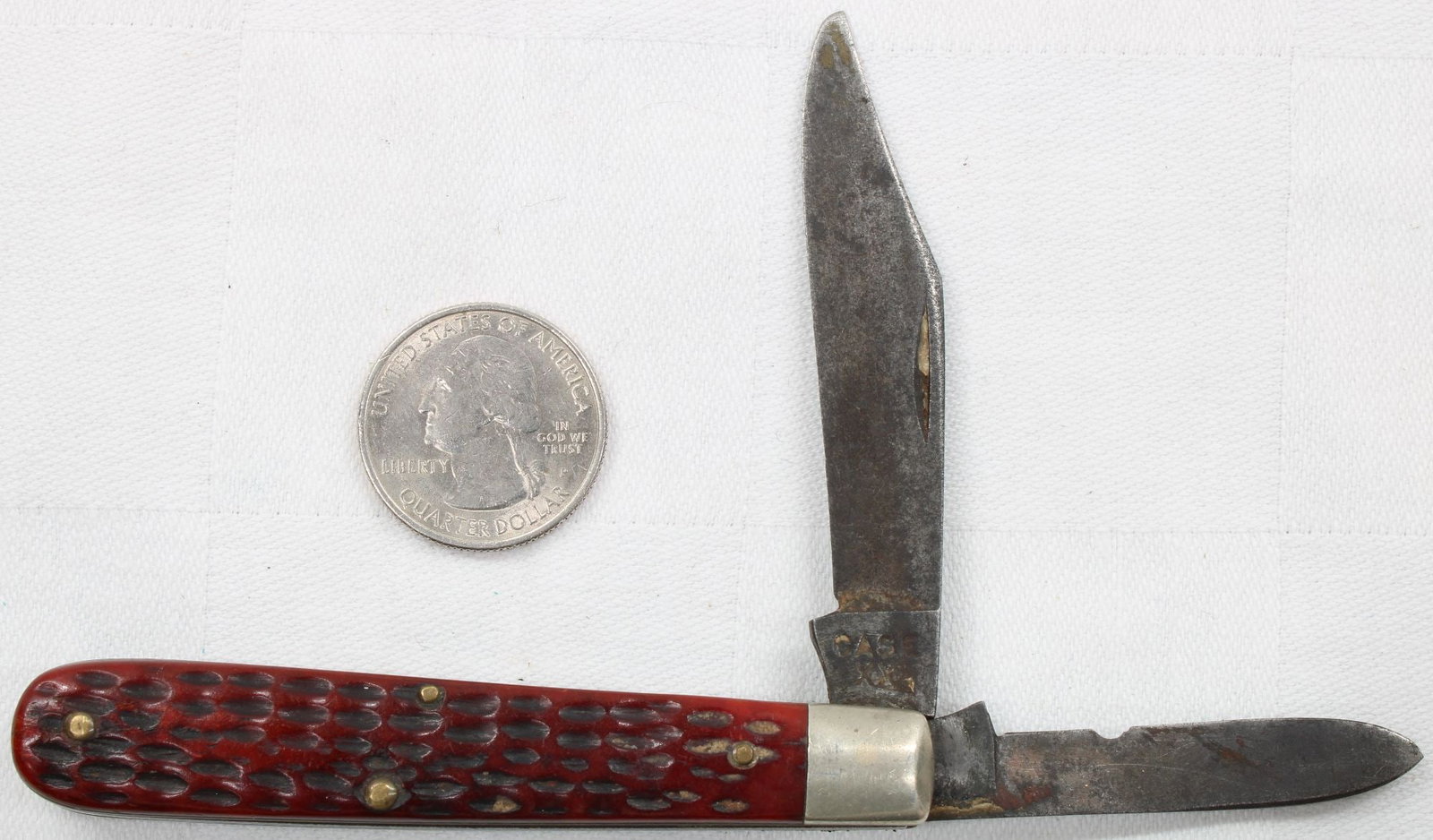 Case XX 2-Blade Folding Pocket Knife - Red Jigged Handle: Two-blade folding pocket knife with red jigged composition handle. Tang stamped Case XX. Blades show notable patina, oxidation, and wear consistent with age and use. Handle appears solid. Vintage Case