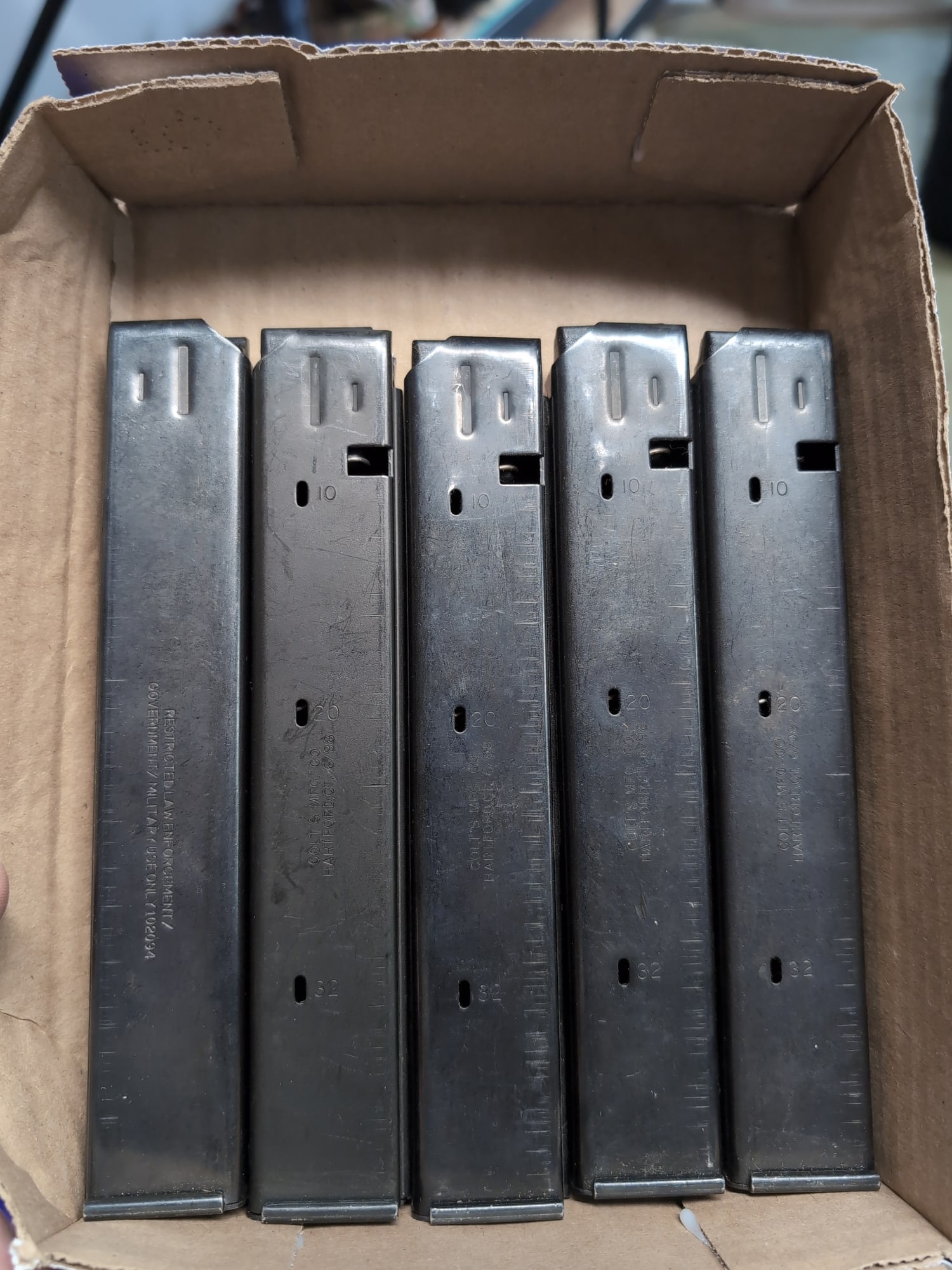 Set of Five Colt 9mm NATO SMG Magazines: A collection of five Colt 9mm NATO submachine gun magazines. Each magazine features witness holes at 10, 20, and 32 rounds. Markings include 'COLT'S MFG. CO. HARTFORD, CT. 6/98' and 'RESTRICTED LAW EN