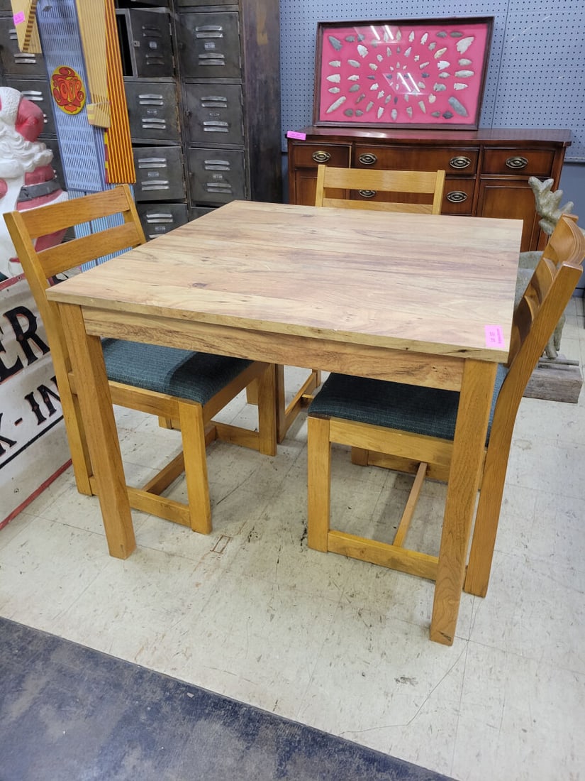 4 Piece Wooden Dining Set with Upholstered Chairs: A 4 pcdining set featuring a square wooden table and four matching chairs. The chairs are constructed with wooden frames, horizontal slat backs, and seats upholstered in a dark blue textured fabric.