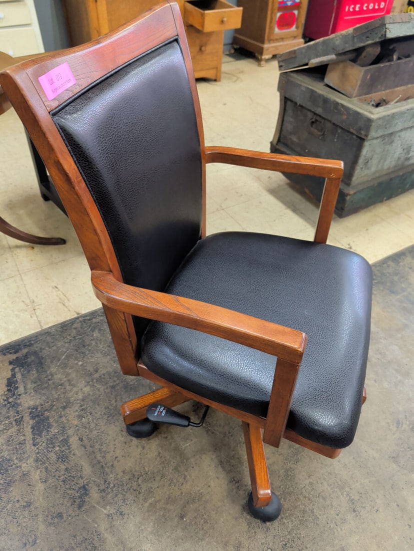 Wood Frame Office Chair with Black Upholstery and: An office chair featuring a wooden frame, black textured upholstery on the seat and backrest, and a swivel base equipped with casters. The chair includes armrests and a manual height adjustment lever.