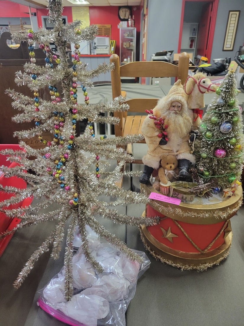 Christmas Decor Set with Santa Figurine, Tabletop: This collection includes a decorative Santa Claus figurine seated on a drum-shaped base alongside a small, flocked tabletop Christmas tree. The set also features a separate metallic-finish tabletop tr