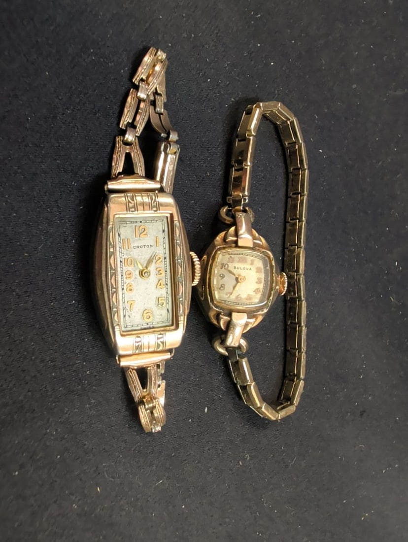 Bulova and Croton Ladies Wristwatch Set: A collection of two ladies wristwatches. The set includes one Bulova timepiece with a round case and a metal link bracelet, and one Croton timepiece featuring a rectangular case with decorative