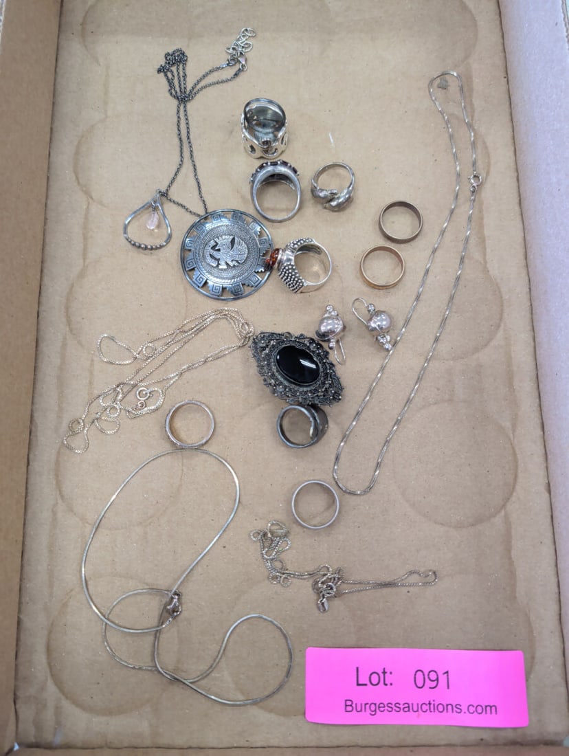 Assorted Sterling Silver Jewelry Collection Includ: A collection of assorted jewelry pieces, primarily composed of sterling silver. The lot includes multiple necklaces with various chain styles, several rings featuring stone settings and metal designs,