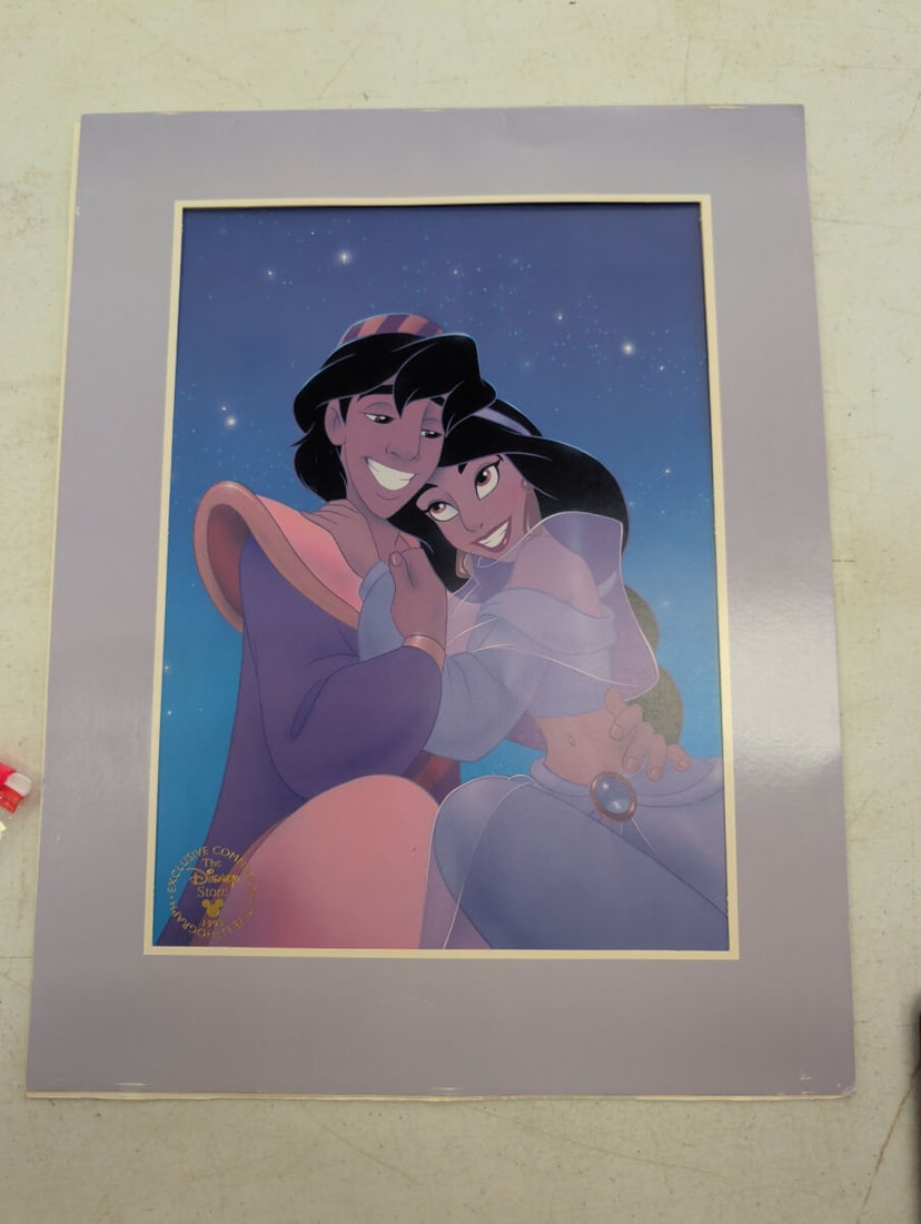 1993 Walt Disney Store Exclusive Commemorative Ala: A 1993 Disney Store exclusive commemorative lithograph featuring Aladdin and Jasmine. The print is presented in a matting and includes the original folder cover.