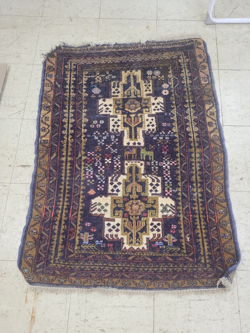 Hand-Knotted Wool Area Rug with Geometric and Anim: A hand-knotted wool area rug featuring a dark blue field with central geometric medallions and stylized animal figures. The rug is framed by a multi-layered border with repeating patterns in earth ton