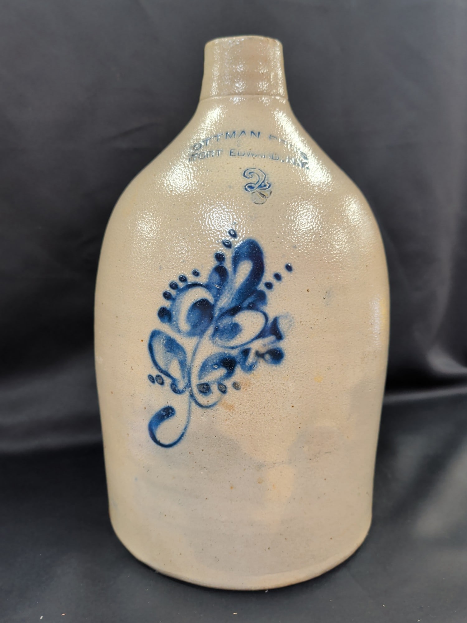 Ottman Bros., Fort Edward, N.Y. 2 Gallon Salt-Glaz: Antique 2 gallon salt-glazed stoneware jug manufactured by Ottman Bros. of Fort Edward, New York. This desirable marked example features a beautifully hand-painted cobalt blue stylized floral decorati