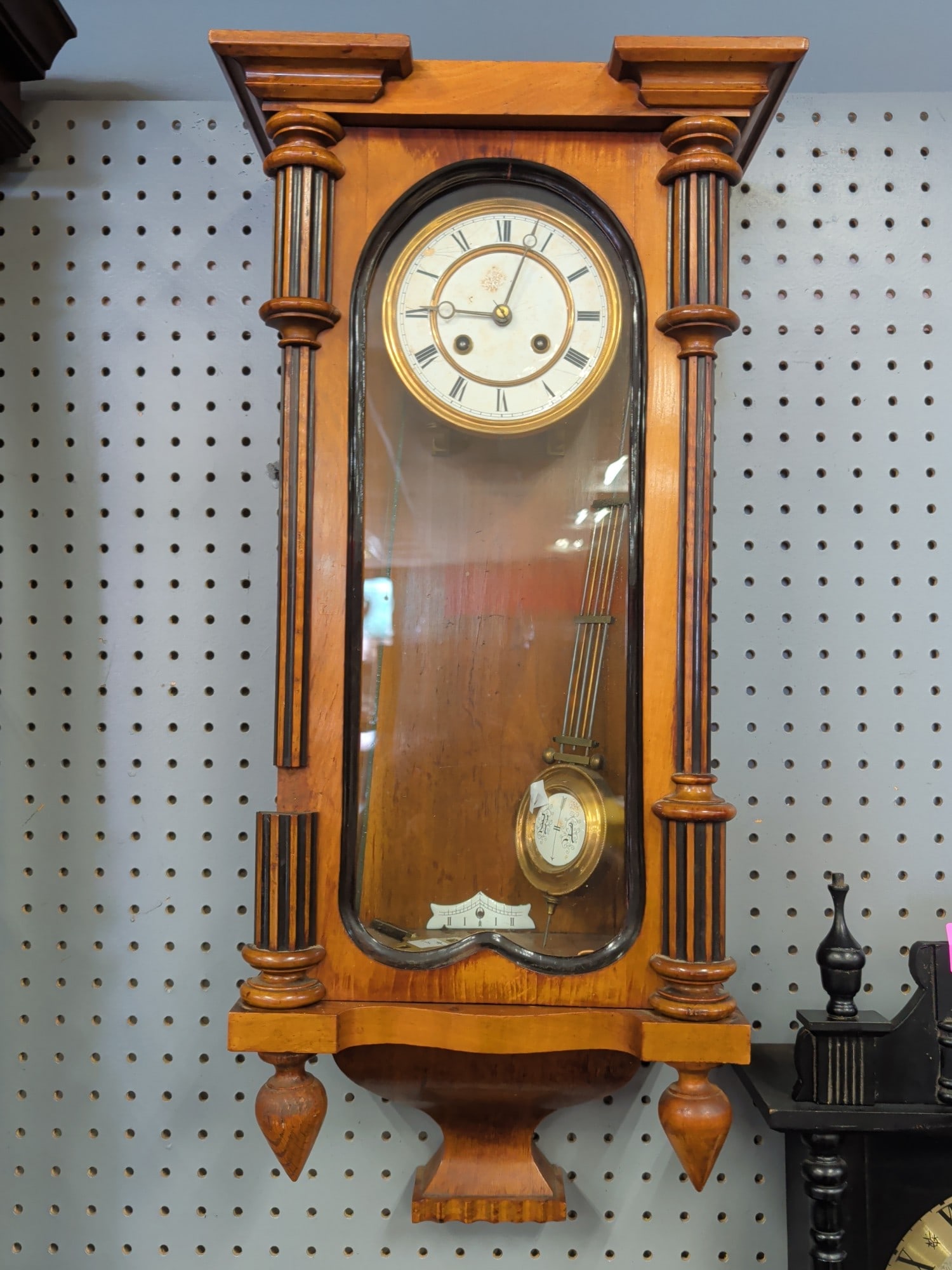 Vienna Style Walnut Regulator Wall Clock with Porc: Late 19th to early 20th century Vienna-style regulator wall clock housed in a walnut case with turned ebonized columns, arched glazed door, porcelain Roman numeral dial, and decorative brass-faced pen