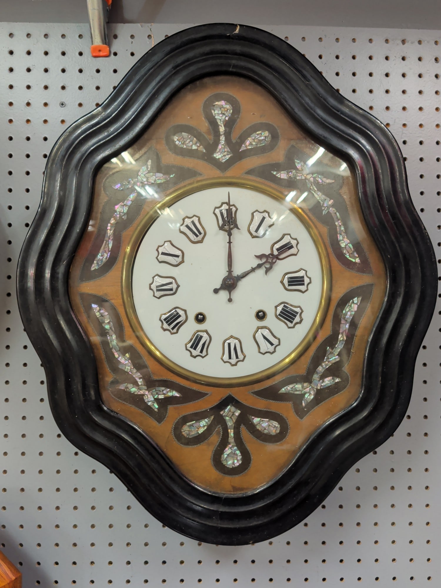 Victorian Ebonized Mother-of-Pearl Inlaid Cartel W: Victorian ebonized cartel-style wall clock featuring a richly molded ebonized wood case accented with hand-laid mother-of-pearl floral and ribbon inlay surrounding a white porcelain dial with applied 
