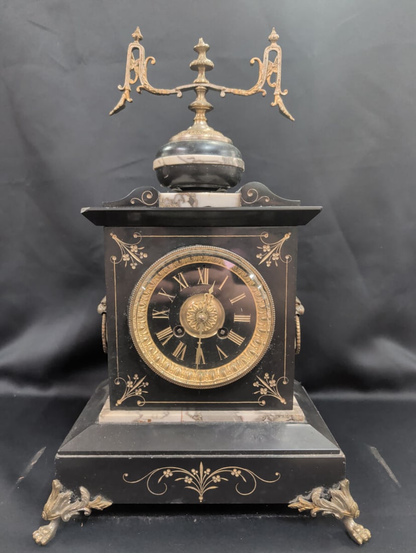 French Napoleon III Black Marble Mantel Clock with: Late 19th-century French Napoleon III mantel clock featuring a polished black marble case accented with gilt metal mounts and engraved gilt decoration. The architectural case is adorned with lion mask