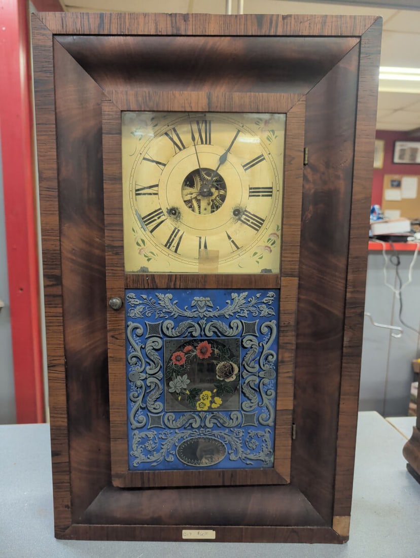 Seth Thomas Weight-Driven Wall Clock, Plymouth Hol: Mid-19th century Seth Thomas weight-driven wall clock housed in a figured walnut veneered case with molded frame and single glazed door. The clock features a painted Roman numeral dial with visible op