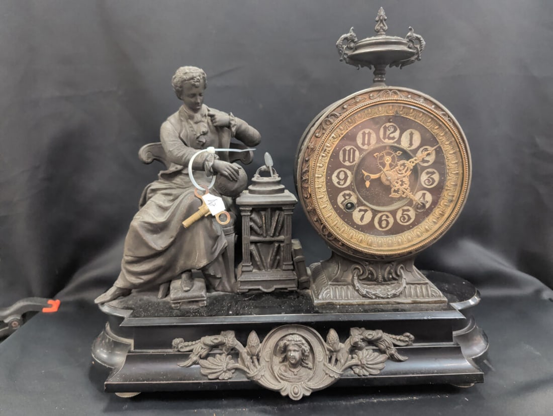 Ansonia Figural Iron Mantel Clock with Renaissance: Late 19th-century Ansonia figural mantel clock featuring an ornate spelter and iron case depicting a seated Renaissance gentleman beside a pedestal supporting the clock movement. The architectural cas