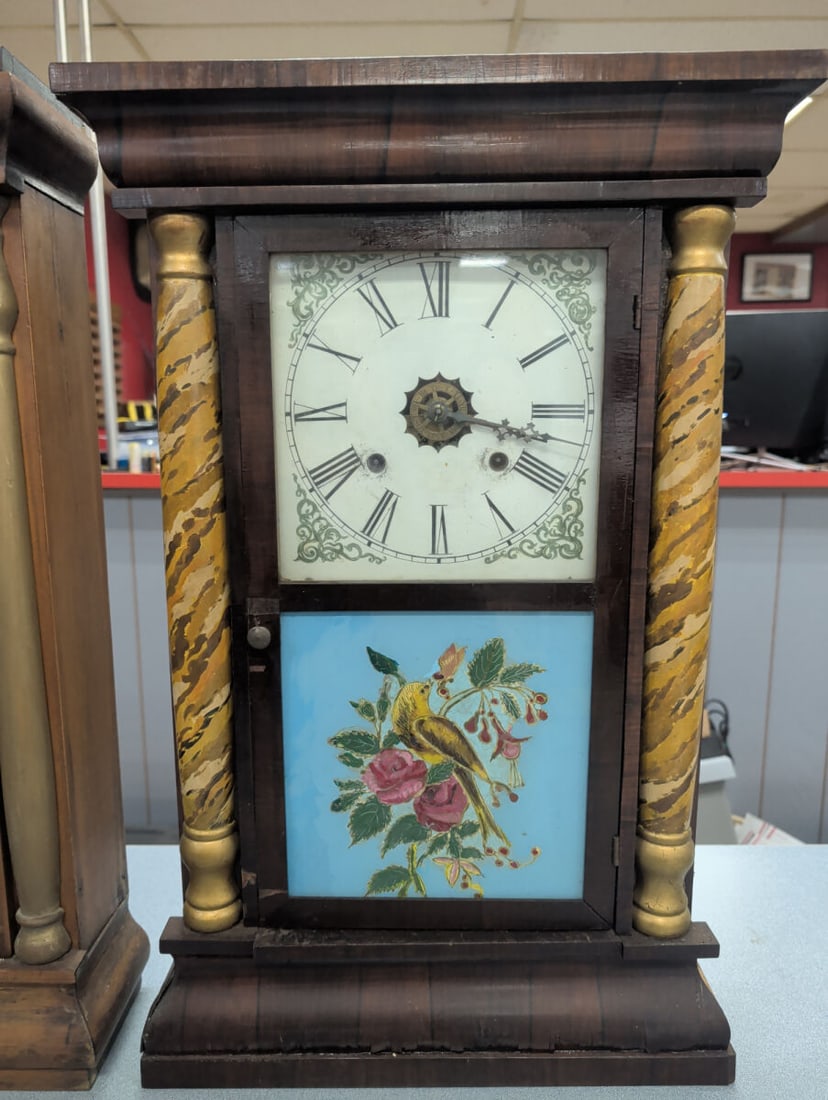 Waterbury Column Shelf Clock with Painted Bird Pan: Antique Waterbury Clock Company shelf clock housed in a walnut-finished case with decorative faux marble columns and a reverse-painted lower glass panel depicting a yellow songbird among blooming rose