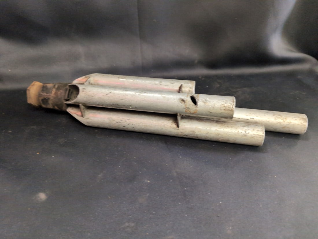 Industrial Three-Chime Steam Whistle Horn: Industrial multi-chamber steam whistle or horn featuring a metal triple-tube assembly with a threaded inlet connection. Measures approximately 12 inches in length. Exhibits surface wear, discoloration