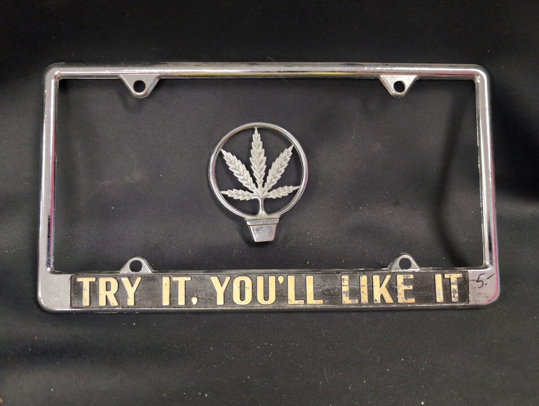 Chrome License Plate Frame with Marijuana Leaf Emblem and Try It You Will Like It Slogan