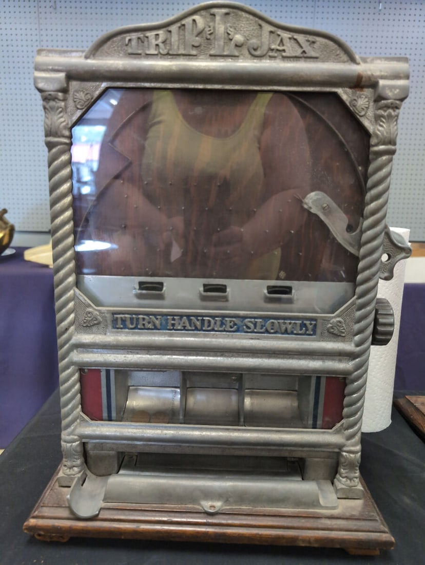 Trip I Jax Triple Penny Slot Machine Trade Stimulator: Trip I Jax triple penny slot machine trade stimulator featuring an ornate cast metal front with twisted column details, text reading Turn Handle Slowly, three coin slots, and a wooden cabinet construc