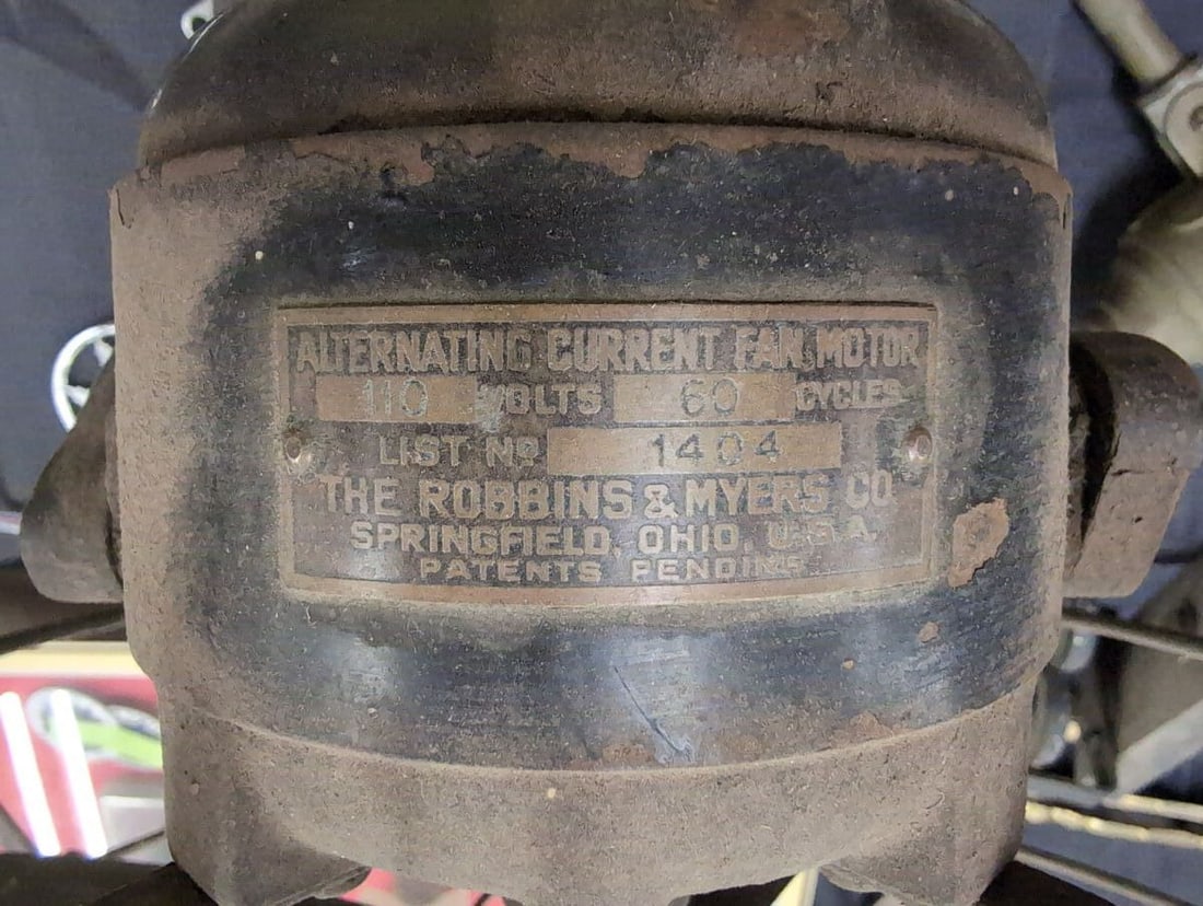The Robbins & Myers Co. Alternating Current Fan Motor List No. 1404: Electric oscillating desk fan manufactured by The Robbins & Myers Co. located in Springfield, Ohio, USA. Features a metal body, four-blade fan, protective wire cage, and a heavy cast iron base. The da