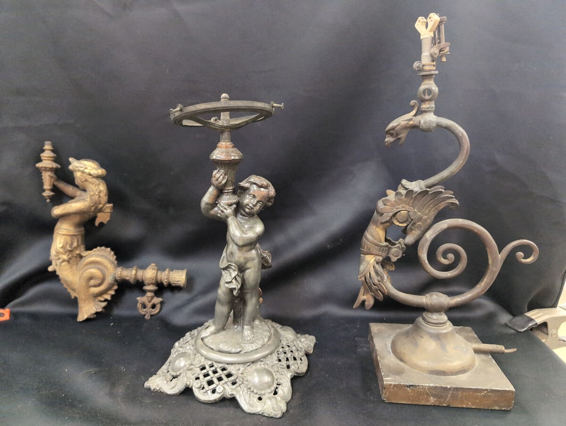 Collection of Three Figural Metal Gas Light Bases and Wall Sconce Parts: Group of three figural metal lighting components, including a wall-mounted mermaid or siren sconce arm with a gilded finish, a cherub or putto figure holding a ring mount on an ornate footed base, and