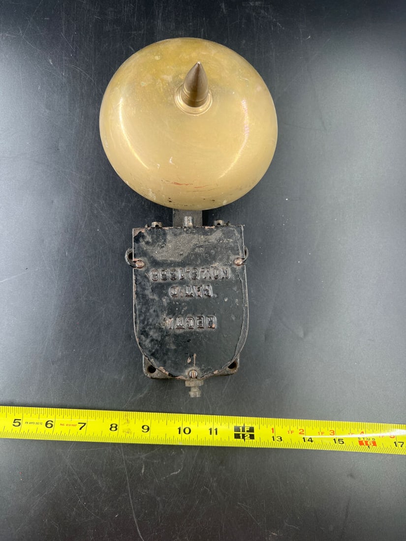 Patented November 9, 1886 Electric Call Bell with Brass Dome and Cast Iron Housing: An electric wall bell featuring a polished brass dome with a central finial and a black-painted cast iron housing. The housing is embossed with patent text reading 'PAT'D NOV. 9, 1886' along with addi