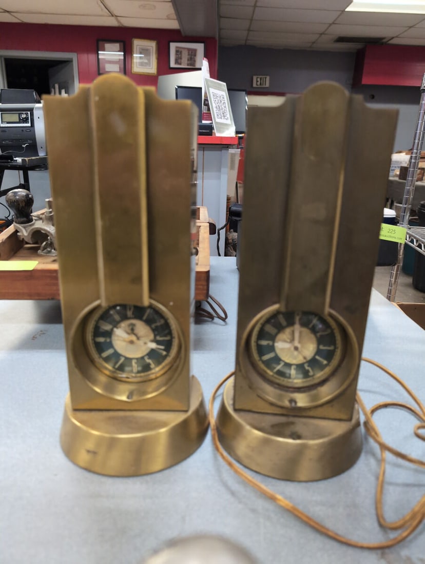 Pair of Stnola Lamps Self-Starting Art Deco Metal Clock Lamps: Pair of matching Stnola Lamps self-starting electric clock lamps featuring an Art Deco design in a brass-tone metal finish. Each unit combines a built-in electric clock with a light socket housing on 