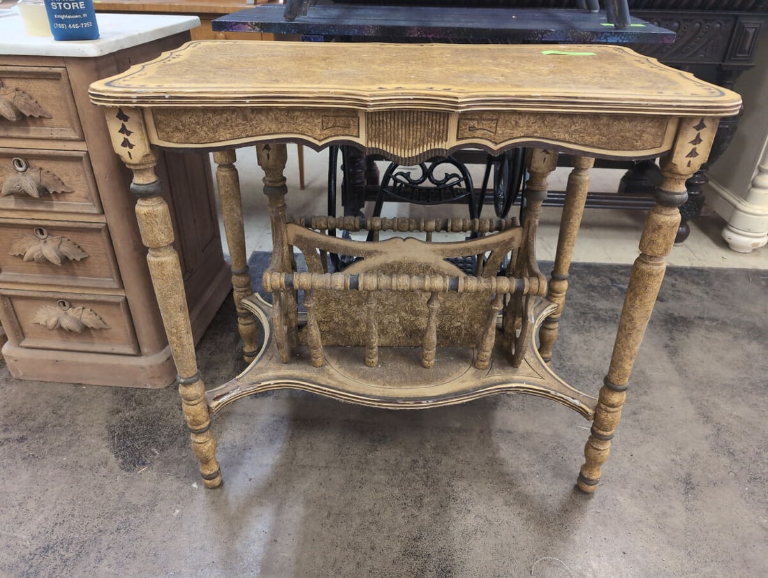 Stained Wood Side Table with Integrated Magazine Rack and Spindle Legs: Stained wood side table featuring an integrated lower magazine rack, turned spindle legs, and decorative painted trim along the scalloped edges of the tabletop and shelf. The piece displays a heavily 