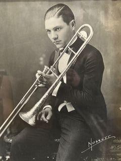 Framed 'Nossett' Vintage Portrait Photograph: Framed black-and-white portrait photograph featuring a seated man holding a trombone. Signed 'Nossett' in the lower right corner. Frame dimensions are H 19 x W15