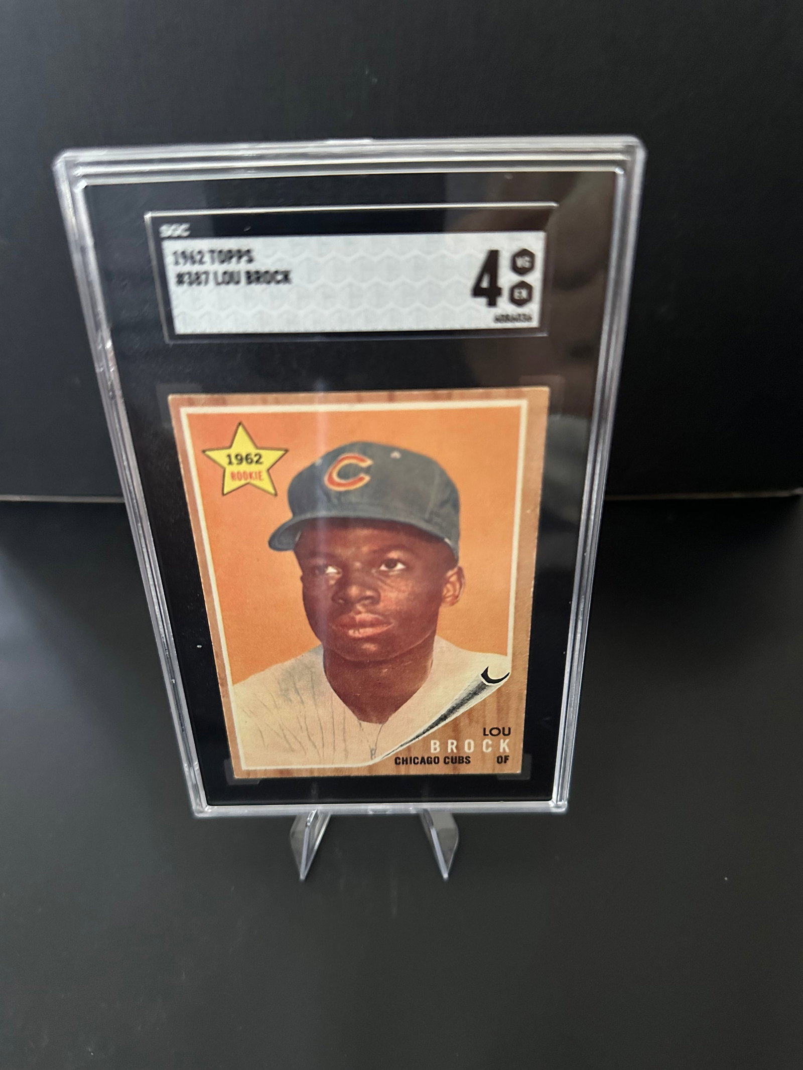 1962 Lou Brock Chicago Cubs Baseball Card: a 1962 Lou Brock baseball card, featuring the Chicago Cubs outfielder. The card is graded with a condition level of 4. It showcases Brock in his Cubs uniform and is notable for its vintage style and h
