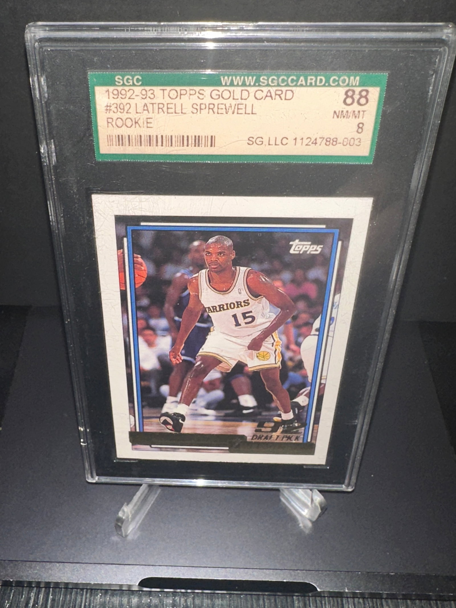 1992-93 Topps Latrell Sprewell Rookie Card: 1992-93 Topps Latrell Sprewell rookie card, numbered #392. It is graded 8 (NM/MT) by SGC, indicating its near mint condition. This card features the player in action, showcasing his time with the Gold