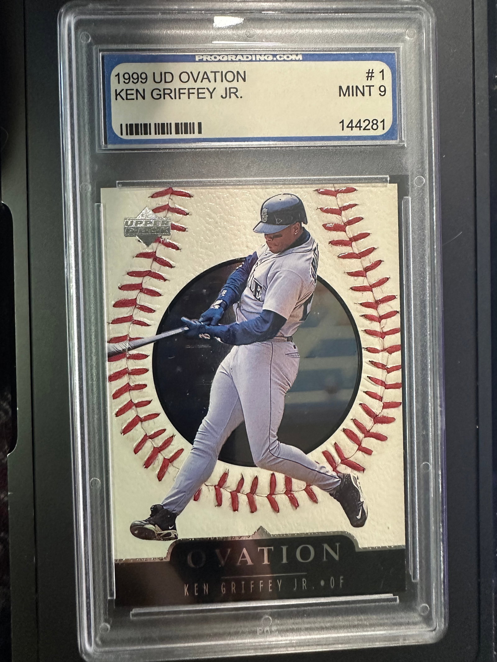 1999 UD Ovation Ken Griffey Jr. Baseball Card: This card is a 1999 Upper Deck Ovation featuring Ken Griffey Jr., one of baseball's legendary outfielders. Graded Mint 9, this collectible card highlights Griffey in his Seattle Mariners uniform. Nota