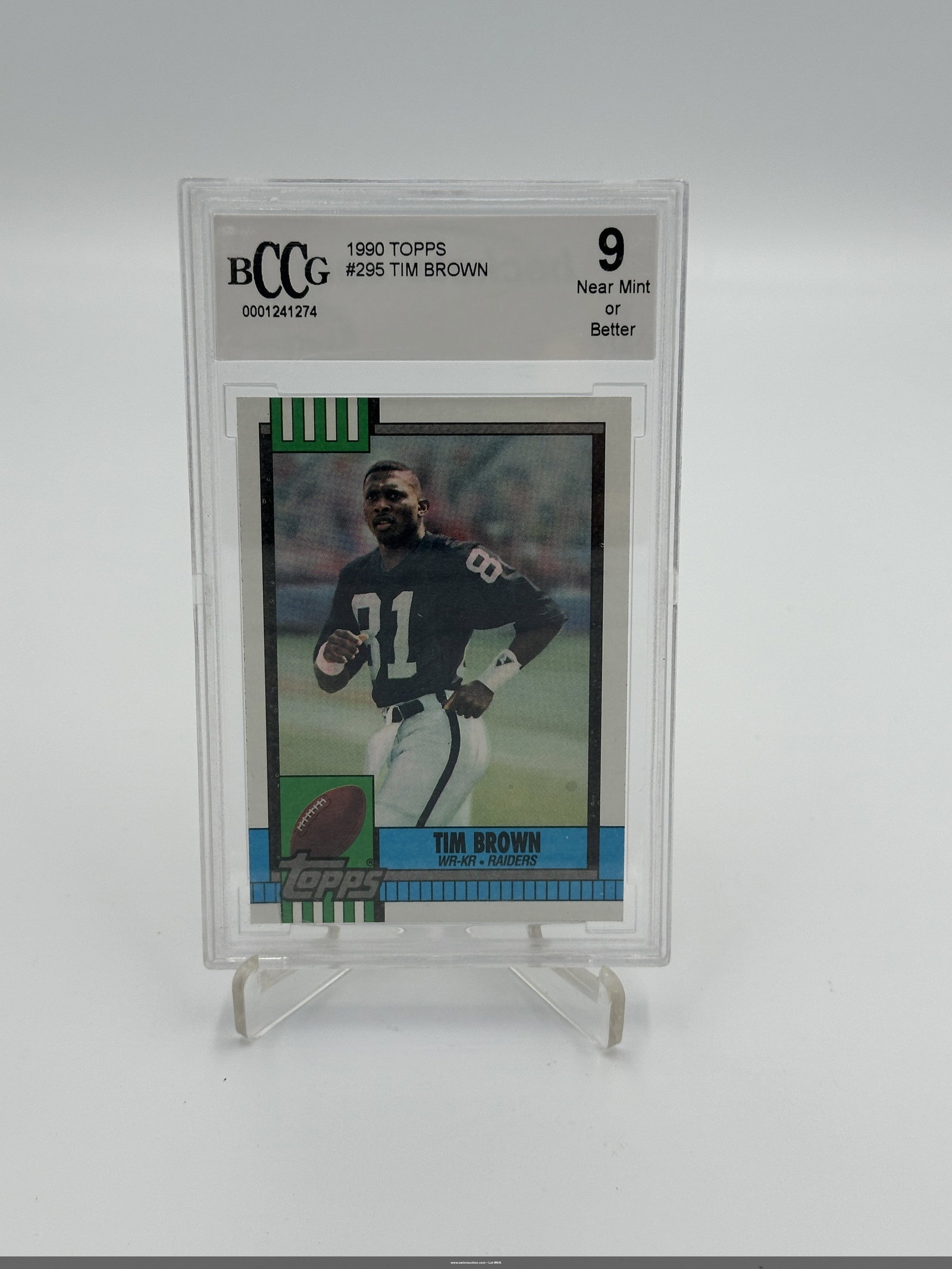 1990 Topps Tim Brown Football Card Graded 9: Tim Brown, a renowned wide receiver for the Los Angeles Raiders. The card is graded BCCG 9 (Near Mint or Better) and is numbered #295 in the series. Tim Brown is depicted in his Raiders uniform, makin