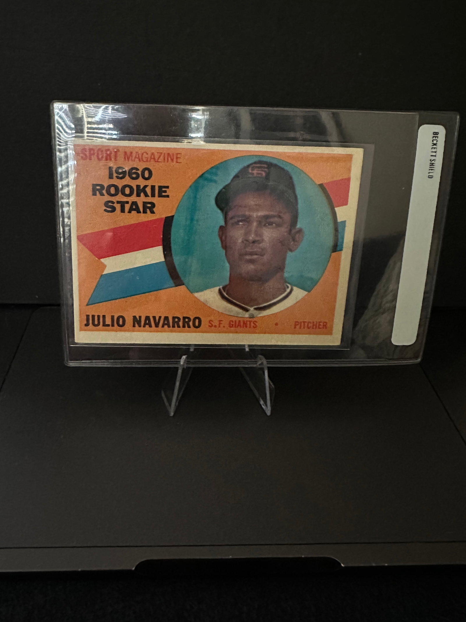 1960 Julio Navarro Rookie Card - San Francisco Giants: This is a 1960 Rookie Star card featuring Julio Navarro, a pitcher for the San Francisco Giants. The card showcases Navarro's image framed in a blue circle with vibrant colors spanning the background,