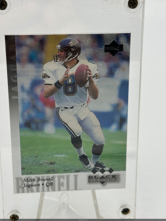 1997 Mark Brunell Black Diamond Card: A collectible trading card featuring Mark Brunell, the quarterback for the Jacksonville Jaguars. This card is part of the Black Diamond series and is a must-have for NFL memorabilia enthusiasts.Shippi