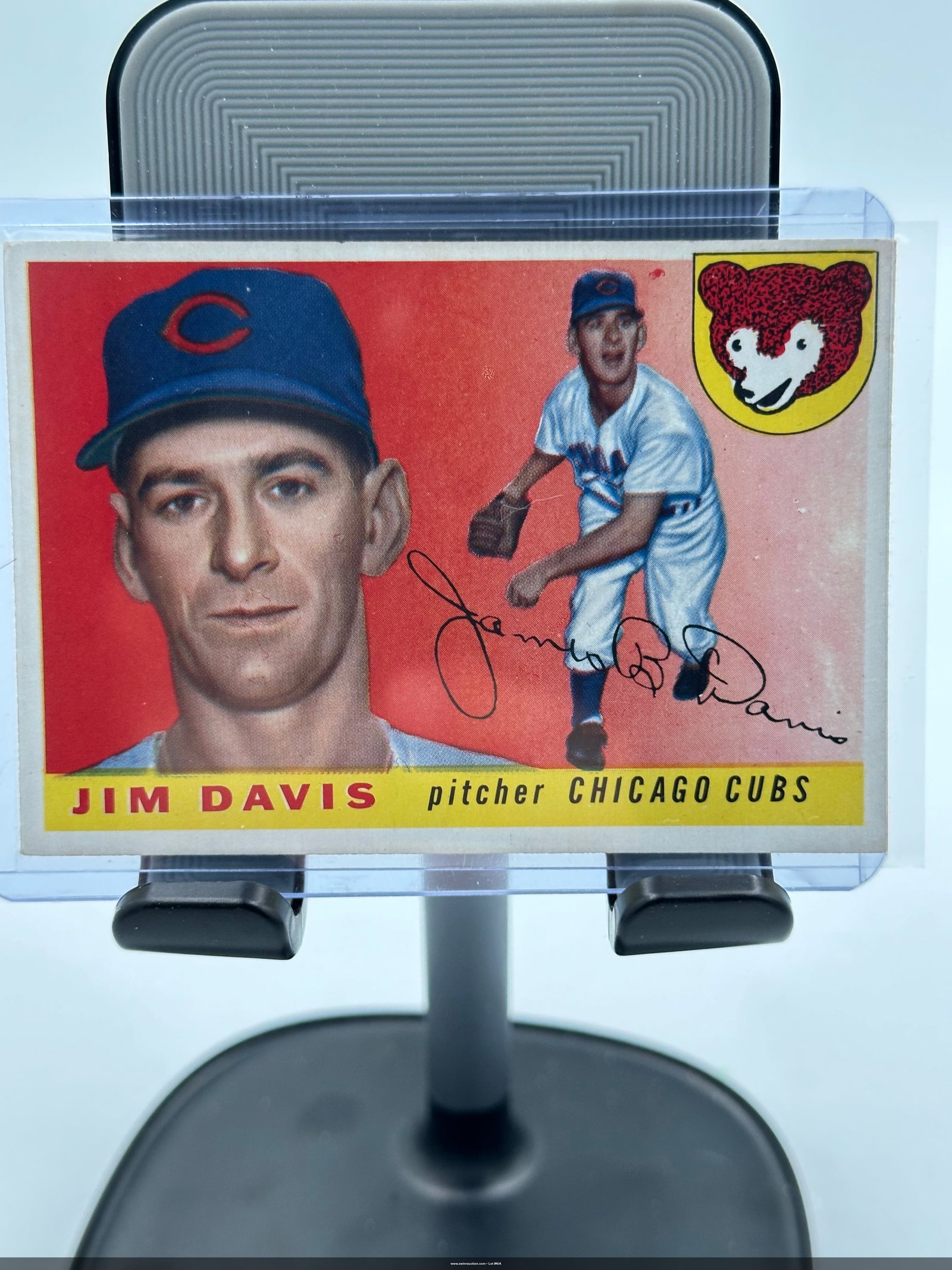 1955 Jim Davis Chicago Cubs Baseball Card: Jim Davis, who played as a pitcher for the Chicago Cubs. The card captures Davis in a dynamic pose alongside a portrait, showcasing the striking red background and the iconic Cubs logo in the top righ