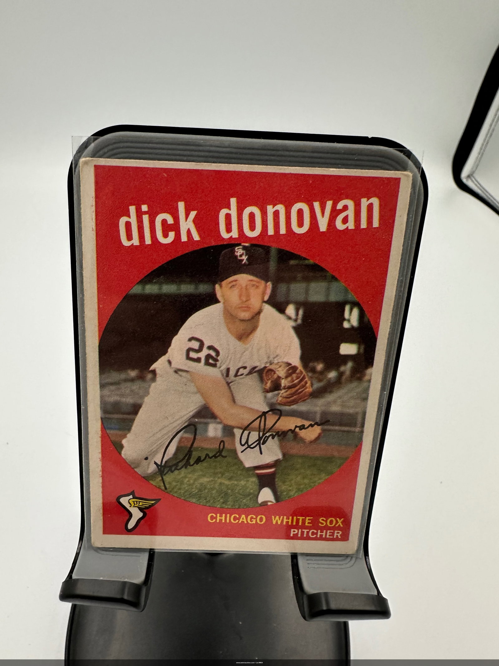 1959 Dick Donovan Baseball Card: a vintage 1959 Dick Donovan baseball card featuring the pitcher for the Chicago White Sox. It showcases Donovan in his uniform, holding a baseball, with a bold red background and his name prominently 
