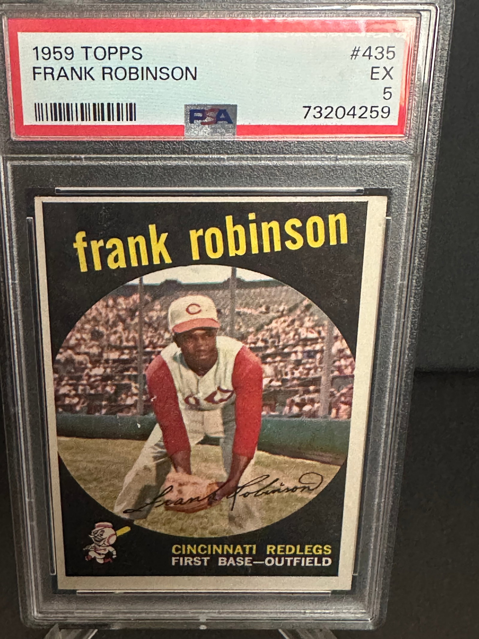 1959 Topps Frank Robinson Baseball Card: Graded 1959 Topps baseball card featuring Hall of Famer Frank Robinson, designated as card #435. The card depicts Robinson, notable for his time with the Cincinnati Redlegs, playing first base and out