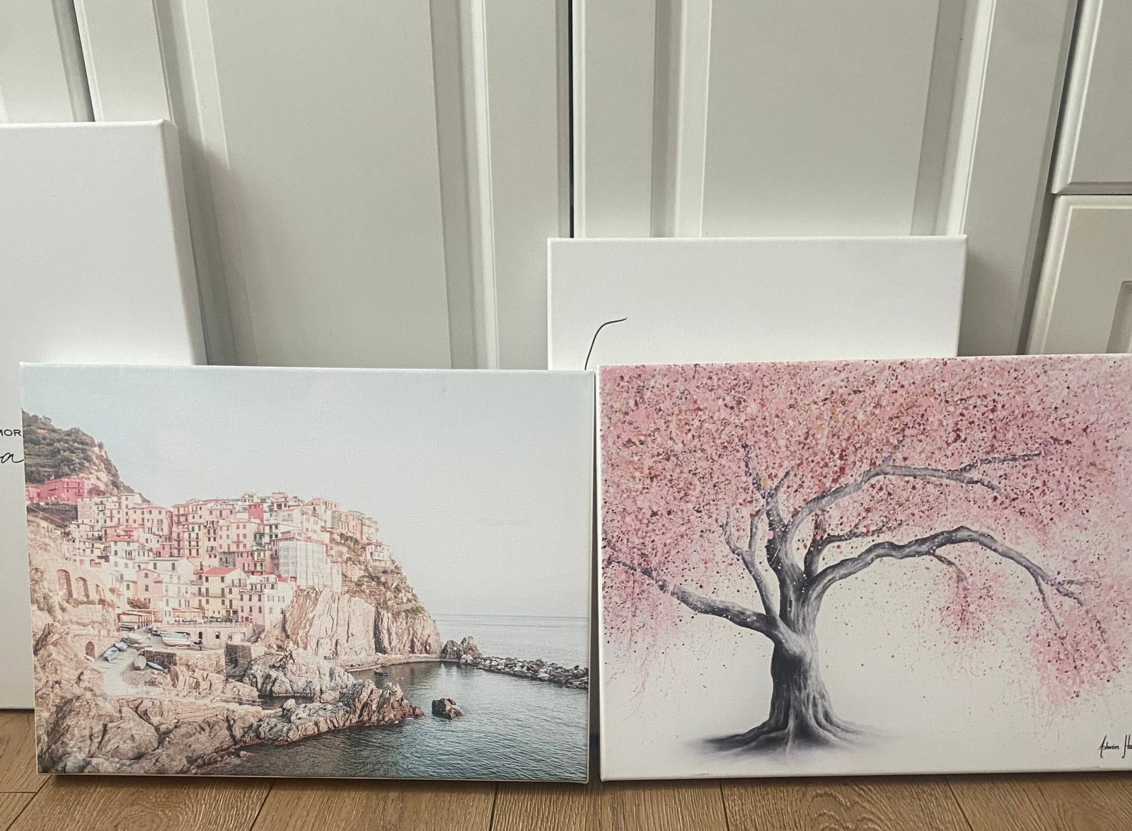 Four Art Prints from Society6: picturesque coastal village with charming colorful buildings perched on rocky cliffs, a beautiful cherry blossom tree and two script drawings. Prints are vibrant and framed on canvas, perfect for