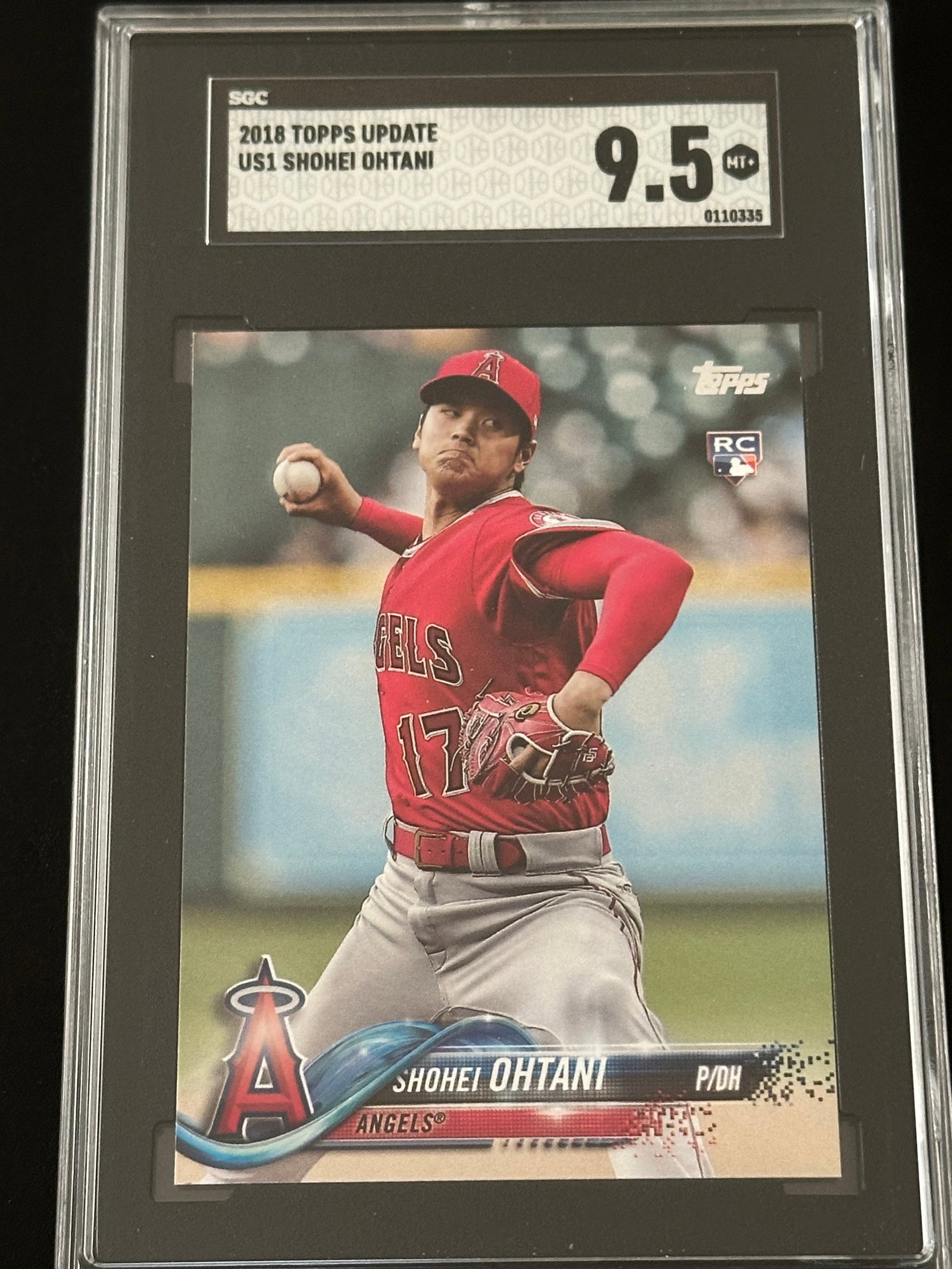 2018 Topps Update Shohei Ohtani #US1 rookie trading card: 2018 Topps Update Shohei Ohtani #US1 rookie trading card in a protective case graded with a 9.5 rating. Shohei Ohtani, depicted pitching in a red Los Angeles Angels jersey.Card Details: 2018 Topps Upd