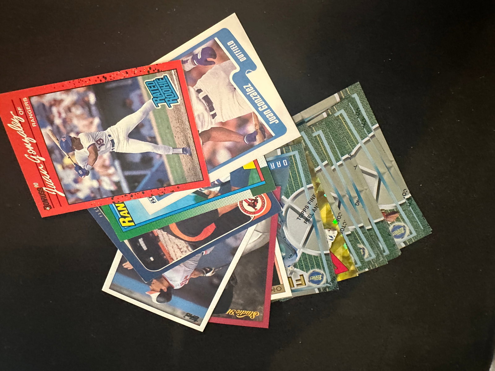 Assorted Vintage 1990s Baseball Trading Cards: This is a collection of various vintage baseball cards from the early 1990s, including brands like Topps, Fleer, and Donruss. Notable cards featured include a Juan Gonzalez 1991 Fleer Rated Rookie