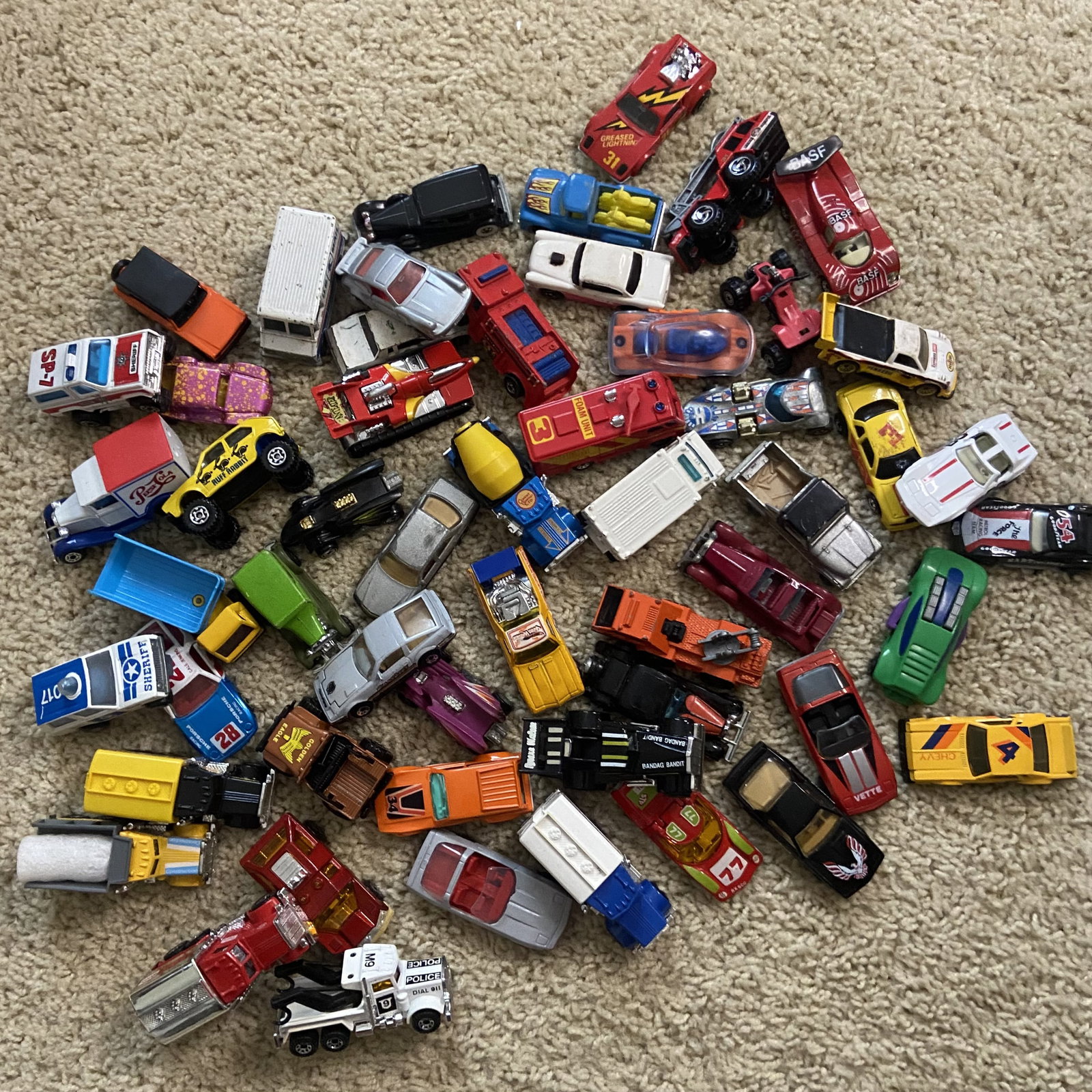 Vintage Hot Wheels: Large lot of various die-cast toy cars resembling vintage matchbox models.