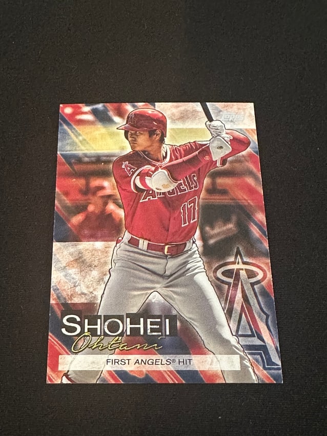 Rookie Card -2018 Topps Shohei Ohtani First Angels Hit Card: This is a 2018 topps baseball card featuring shohei ohtani in his los angeles angels uniform. The card commemorates his 'first angels hit' with the team. It is a standard trading card from the 2018 to