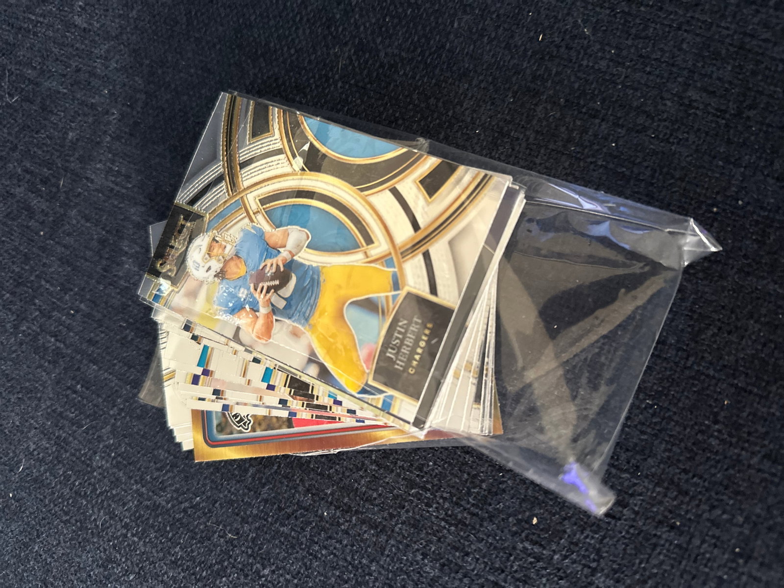 Stack of Panini Select football cards: This is a stack of Panini Select football cards showing Los Angeles Chargers quarterback Justin Herbert. The cards are preserved in individual protective sleeves within a plastic bag. This set is