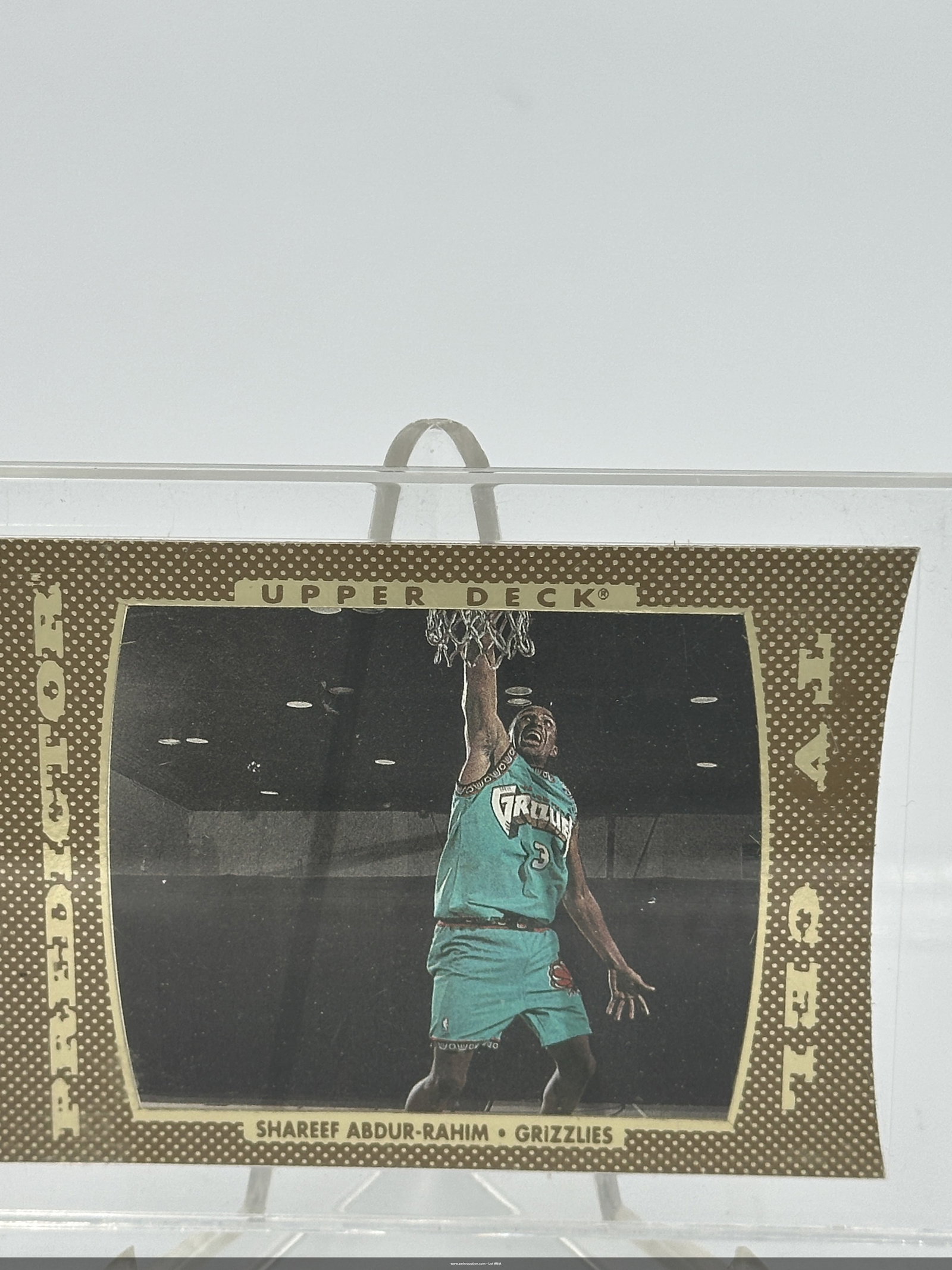 Shareef Abdur-rahim Upper Deck Card - Hologram Card: Trading card featuring nba player shareef abdur-rahim, who played for the vancouver grizzlies. It is from the upper deck series and showcases abdur-rahim performing an impressive dunk, dressed in a di
